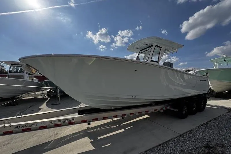 Slide: The Image of 2026 Sportsman Heritage 261 Center Console boat on trailer under blue sky. - 2