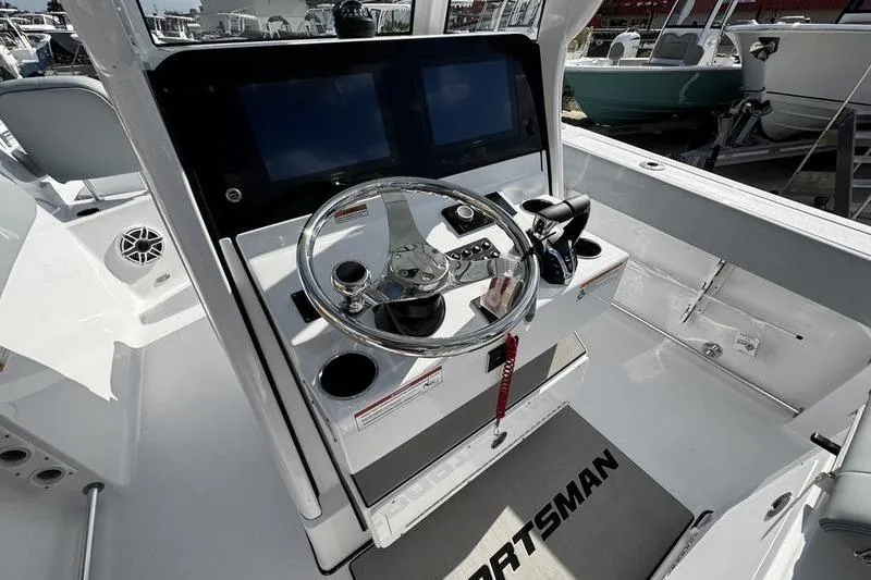Slide: The Image of 2026 Sportsman Heritage 261 Center Console boat dashboard with steering wheel and dual screens. - 20