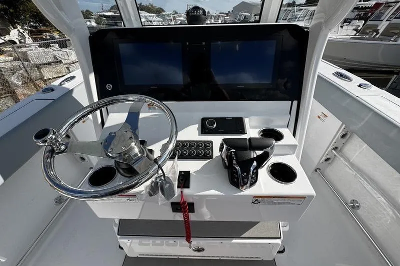 Slide: The Image of 2026 Sportsman Heritage 261 Center Console boat dashboard with steering wheel and dual screens. - 21