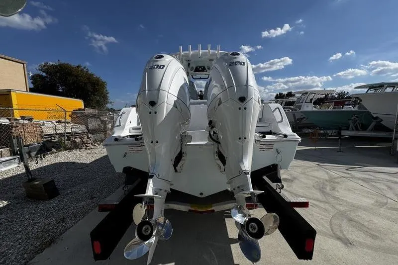 Slide: The Image of 2026 Sportsman Heritage 261 Center Console with dual outboard engines, parked outdoors. - 35