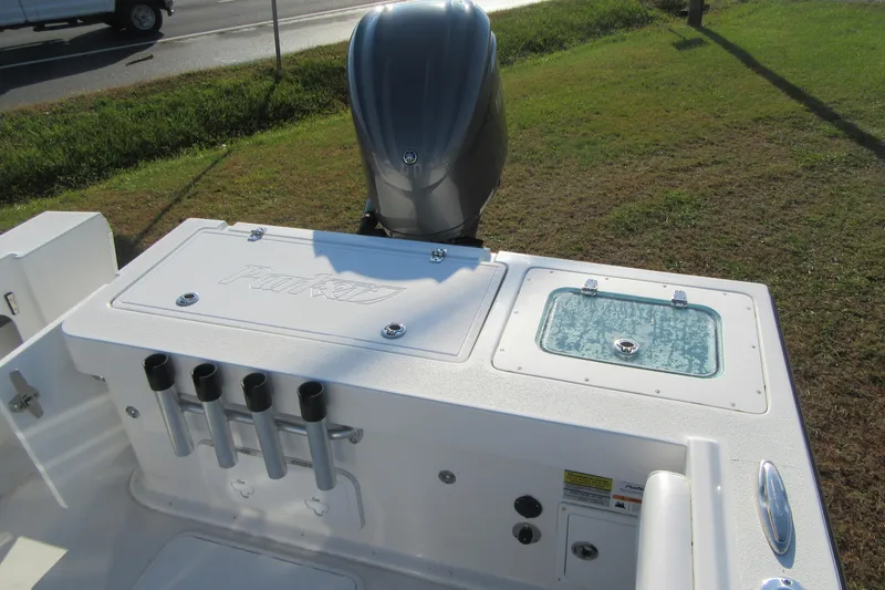 Slide: The Image of 2024 Parker 2320 SL Sport Cabin boat with outboard motor and rod holders. - 11