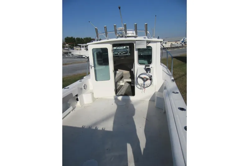 Slide: The Image of 2024 Parker 2320 SL Sport Cabin boat with open deck and cabin entrance. - 17