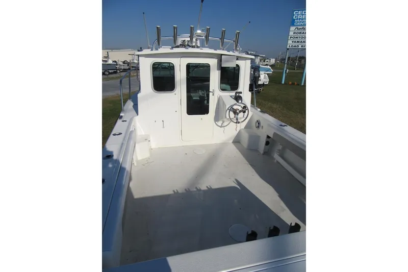 Slide: The Image of 2024 Parker 2320 SL Sport Cabin boat, spacious deck, steering wheel, outdoor setting. - 18