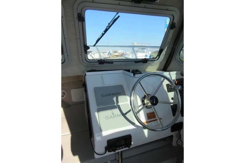 Slide: The Image of 2024 Parker 2320 SL Sport Cabin helm with Garmin navigation system and steering wheel. - 23