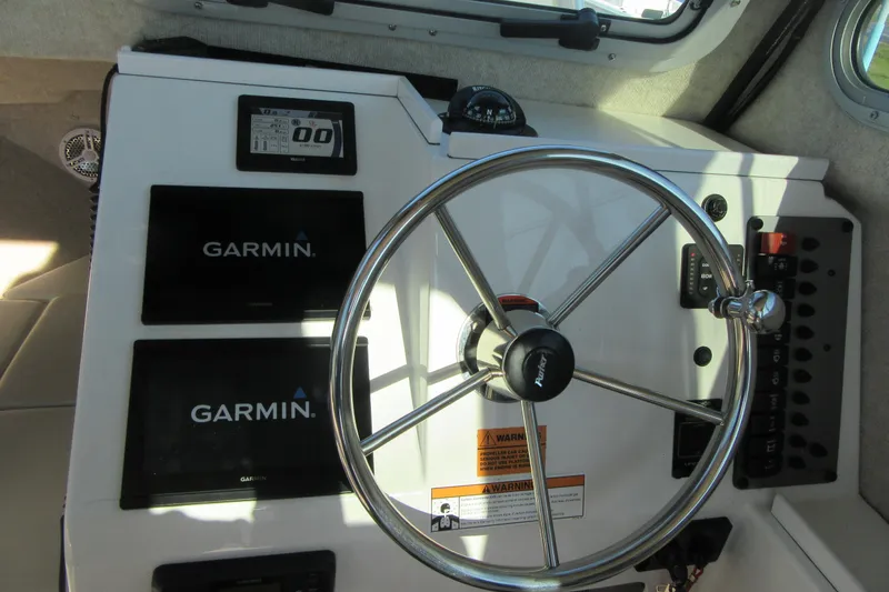 Slide: The Image of 2024 Parker 2320 SL Sport Cabin helm with Garmin displays and steering wheel. - 27