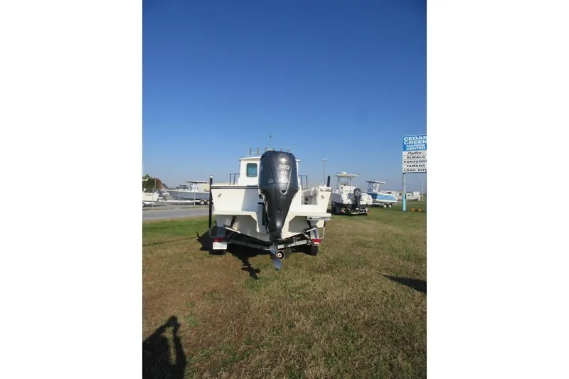 Slide: The Image of 2024 Parker 2320 SL Sport Cabin boat on display, rear view with outboard motor. - 4