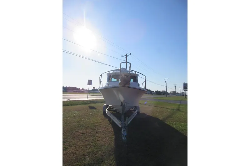Slide: The Image of 2024 Parker 2320 SL Sport Cabin boat on trailer under bright sun. - 6