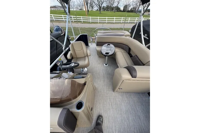 Slide: The Image of 2026 Sylvan Mirage 820 CRS pontoon boat interior with beige seating and steering console. - 5