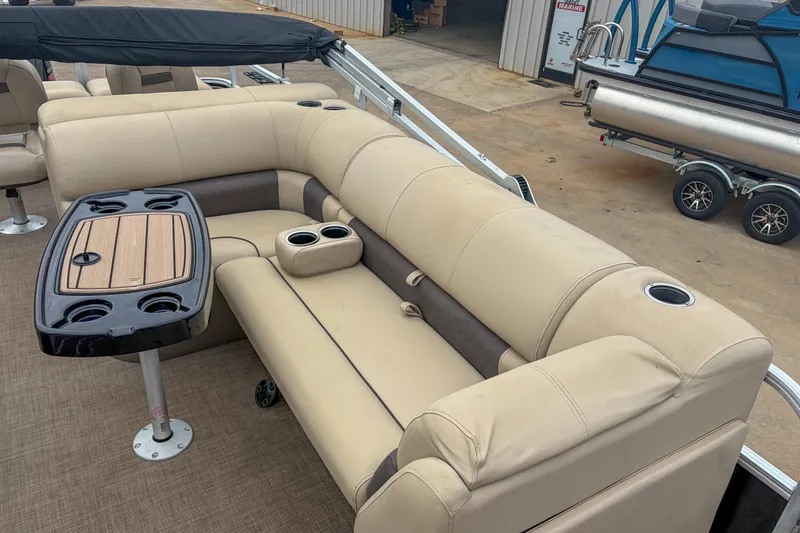 Slide: The Image of 2022 Sun Tracker Fishin' Barge 22 DLX with beige seating and table setup. - 10