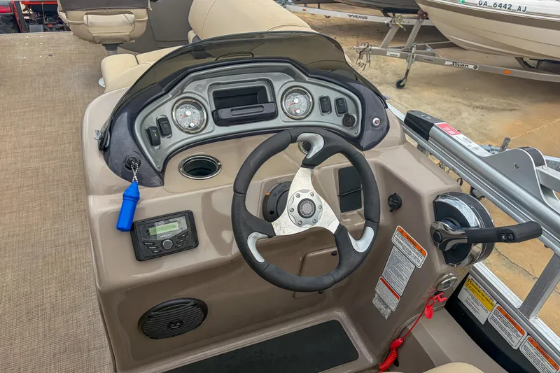 Slide: The Image of 2022 Sun Tracker Fishin' Barge 22 DLX dashboard with steering wheel and controls. - 13