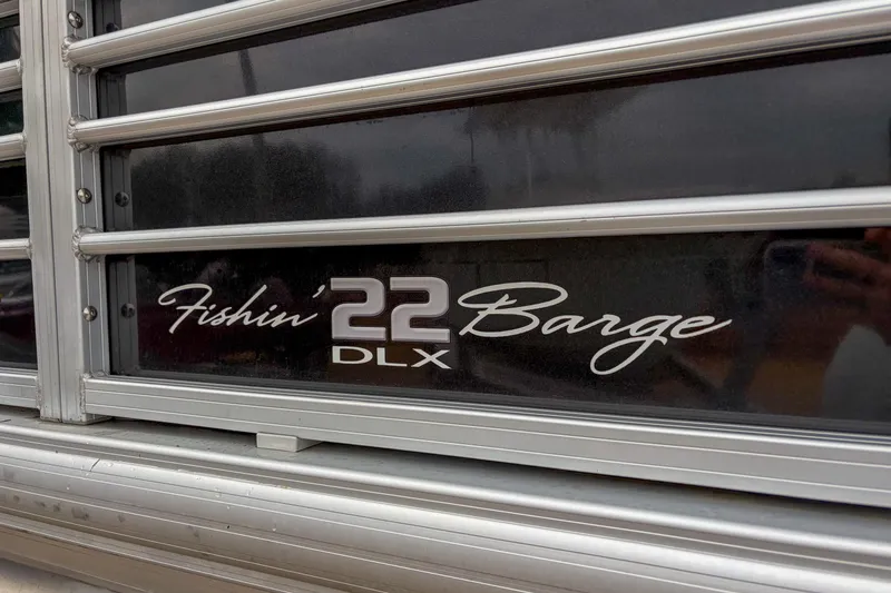 Slide: The Image of 2022 Sun Tracker Fishin' Barge 22 DLX logo on boat exterior. - 4