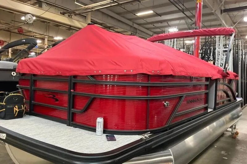 Slide: The Image of 2026 Bennington 22 SSRSF pontoon boat with red cover in a warehouse setting. - 19