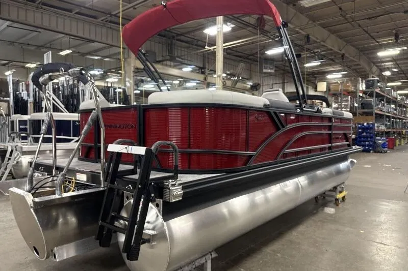 Slide: The Image of 2026 Bennington 22 SSRSF pontoon boat in a factory setting, featuring a red exterior. - 7