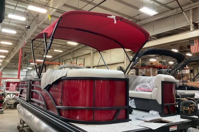 Slide: The Image of 2026 Bennington 22 SSRSF pontoon boat with red canopy in a warehouse setting. - 9