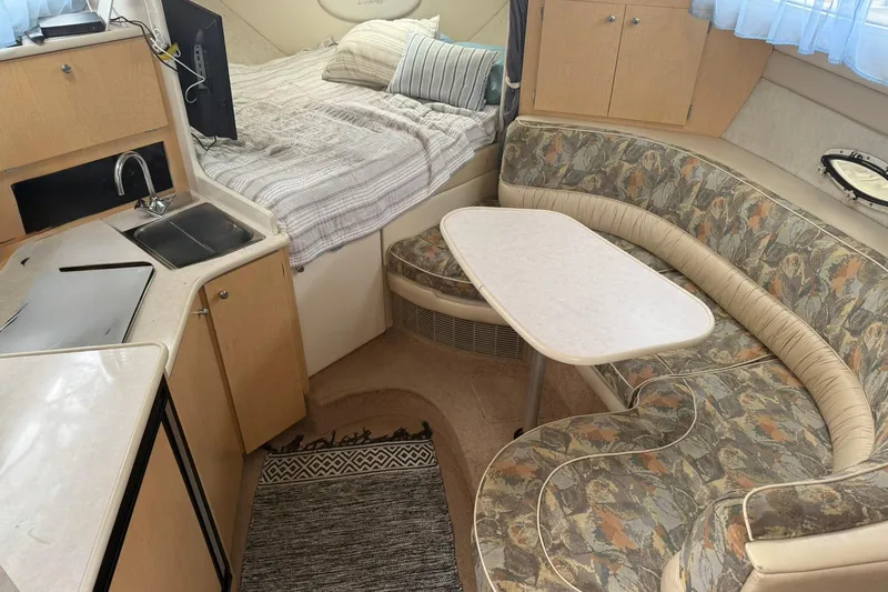 Slide: The Image of Interior of 2000 Bayliner 3055 Ciera Sunbridge DX/LX with kitchenette, bed, and seating area. - 12