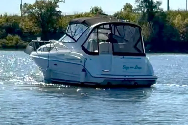 Slide: The Image of 2000 Bayliner 3055 Ciera Sunbridge DX/LX cruising on a calm lake. - 2