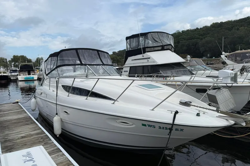 Slide: The Image of 2000 Bayliner 3055 Ciera Sunbridge DX/LX docked at a marina, surrounded by other boats. - 8