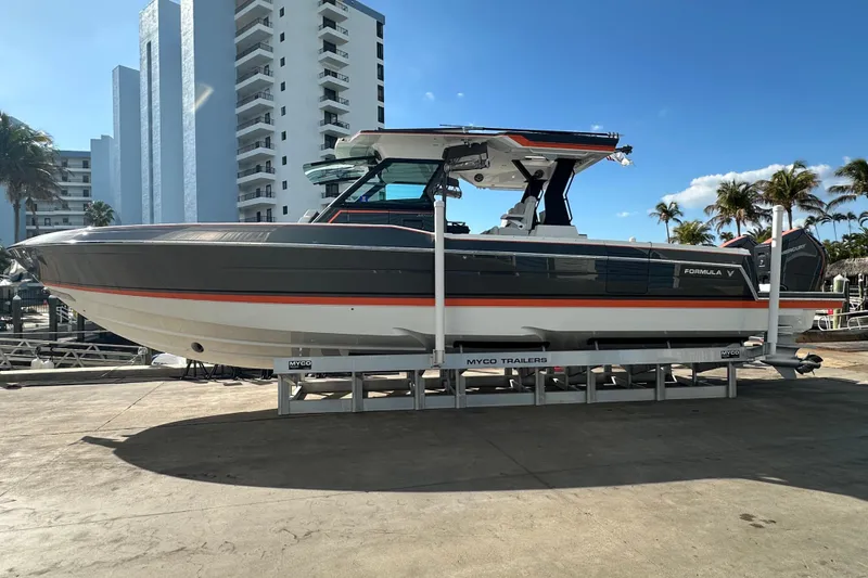 Slide: The Image of 2024 Formula 387 Center Console Fish boat on trailer, urban backdrop, sunny day. - 2