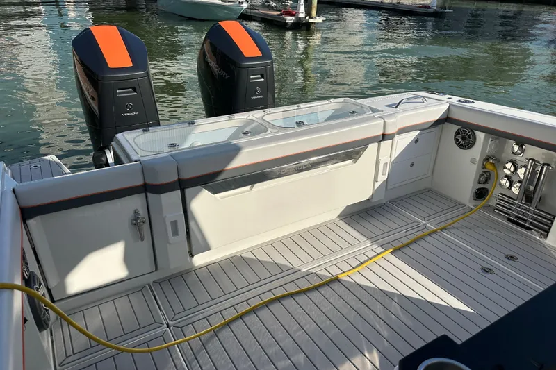 Slide: The Image of 2024 Formula 387 Center Console Fish boat with dual outboard engines, docked on water. - 31
