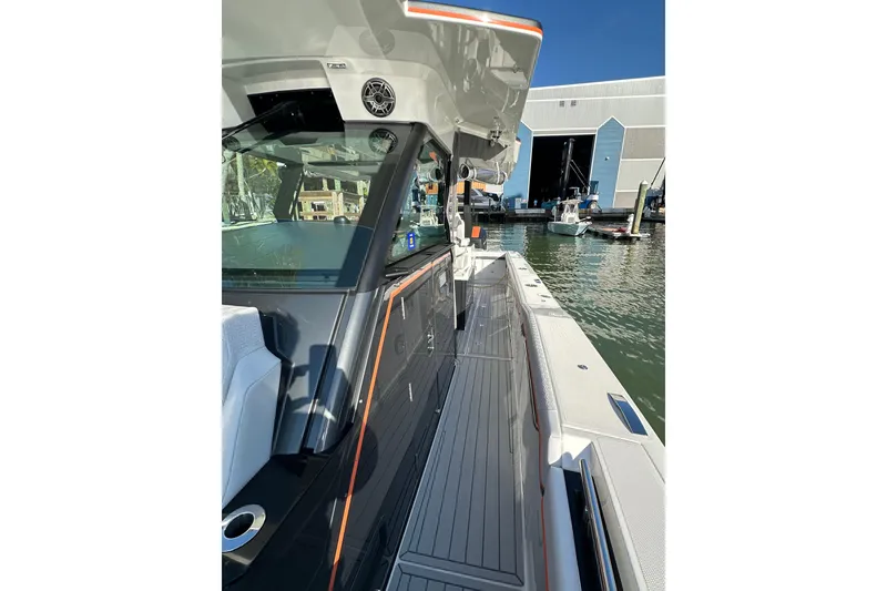 Slide: The Image of 2024 Formula 387 Center Console Fish boat docked near a marina, showcasing sleek design. - 38