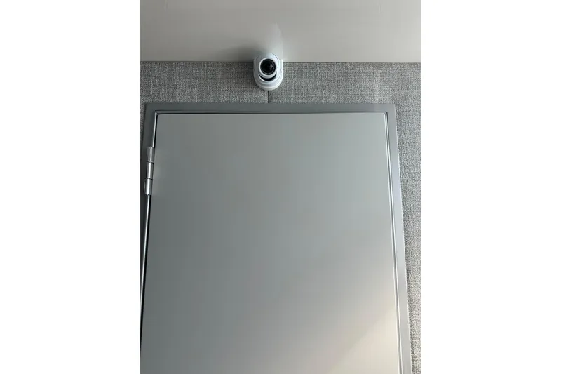 Slide: The Image of Security camera above a closed door on a textured wall. - 55