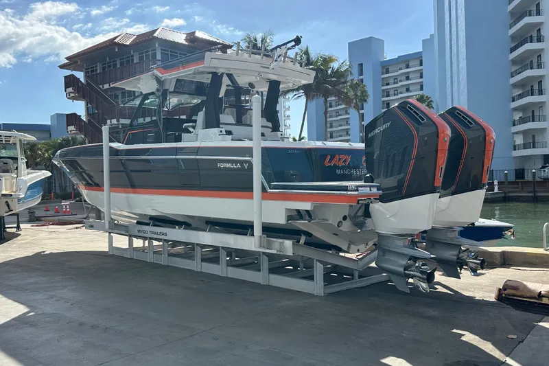 Slide: The Image of 2024 Formula 387 Center Console Fish boat on trailer, dockside with twin Mercury engines. - 8