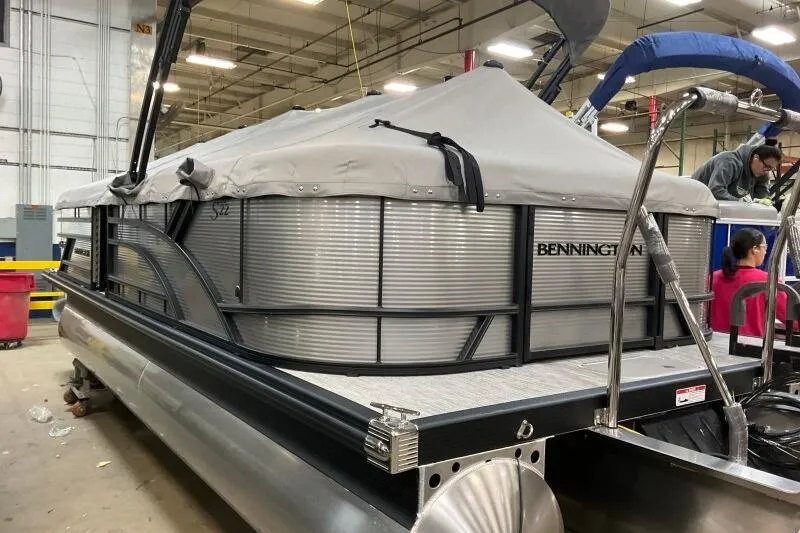 Slide: The Image of 2026 Bennington 22 SSRSF pontoon boat with cover in a warehouse setting. - 20