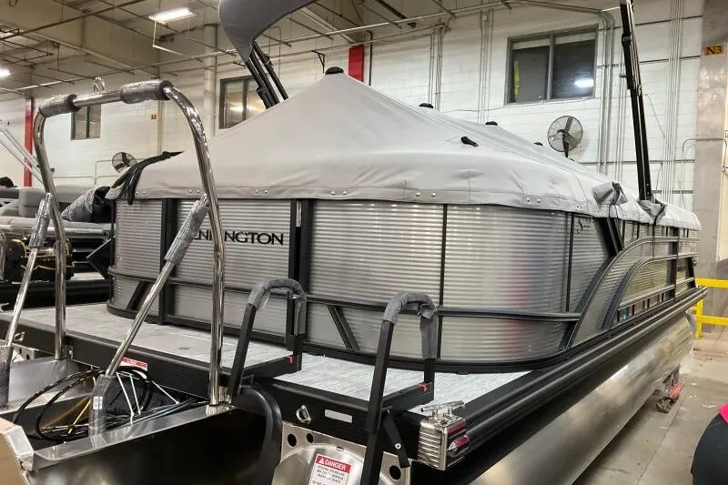 Slide: The Image of 2026 Bennington 22 SSRSF pontoon boat with cover in a warehouse setting. - 21