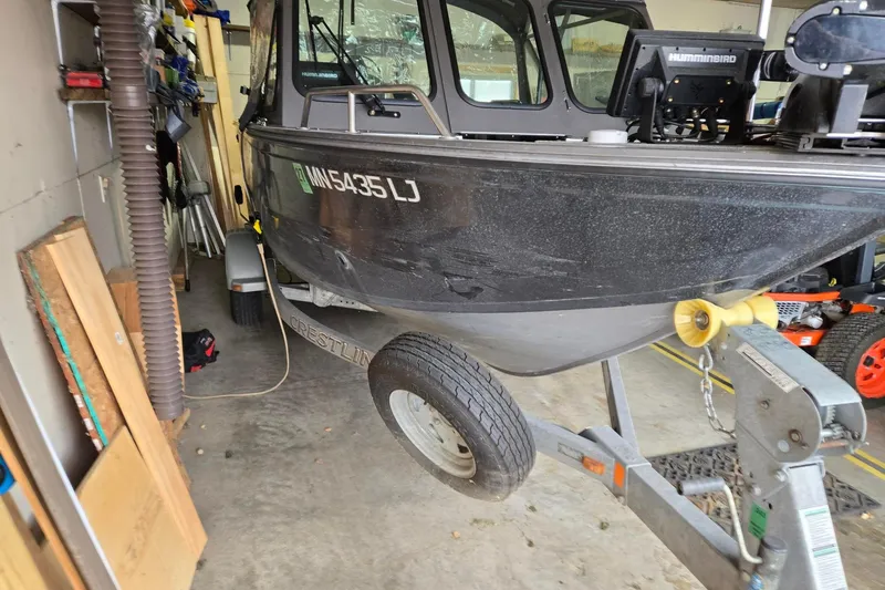 Slide: The Image of 2015 Crestliner 1850 Commander boat on trailer in garage setting. - 3