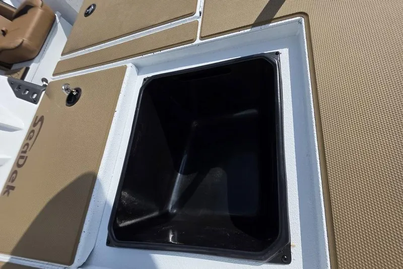Slide: The Image of Open storage compartment on 2026 Xpress H18 boat with SeaDek flooring. - 14