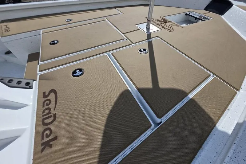 Slide: The Image of 2026 Xpress H18 boat deck with SeaDek padding, featuring storage compartments. - 16