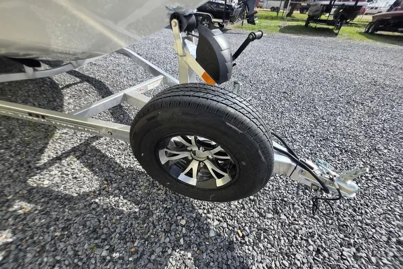 Slide: The Image of 2026 Xpress H18 boat trailer with spare tire on gravel surface. - 18
