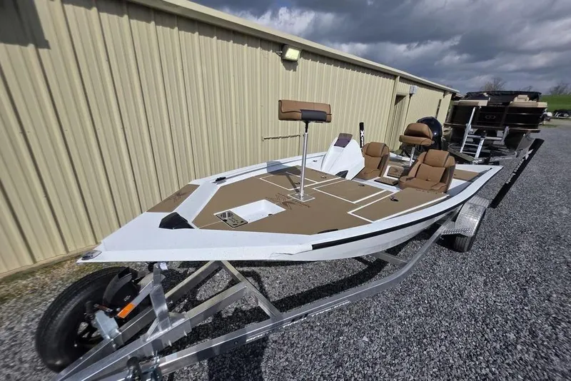 Slide: The Image of 2026 Xpress H18 boat on trailer, parked outdoors, featuring brown seating and deck. - 22