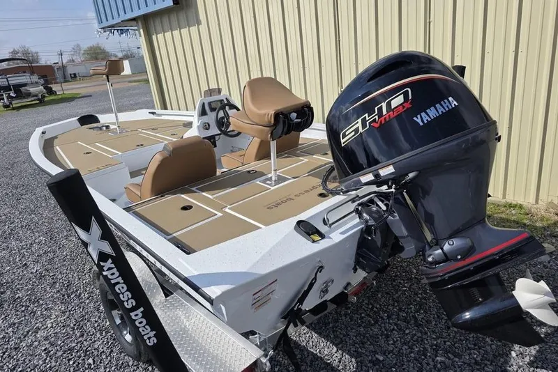 Slide: The Image of 2026 Xpress H18 boat with Yamaha engine, parked on gravel near a building. - 4