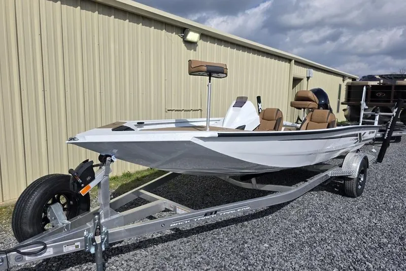 Slide: The Image of 2026 Xpress H18 boat on trailer, parked beside a beige building under cloudy sky. - 6