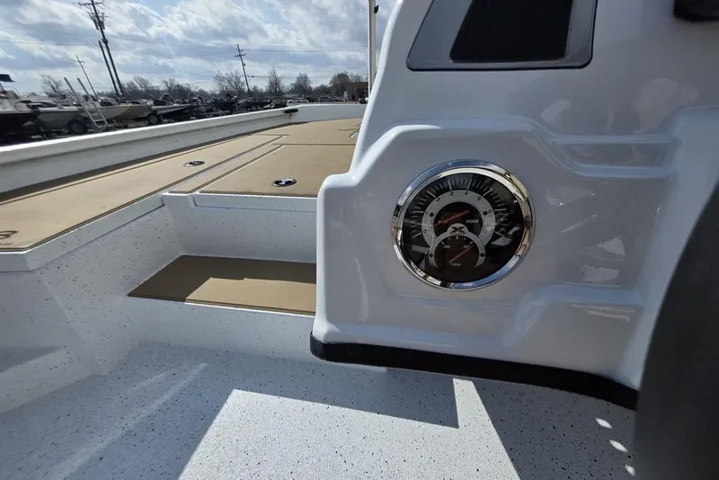 Slide: The Image of 2026 Xpress H18 boat interior with gauge, white and tan deck, under cloudy sky. - 8