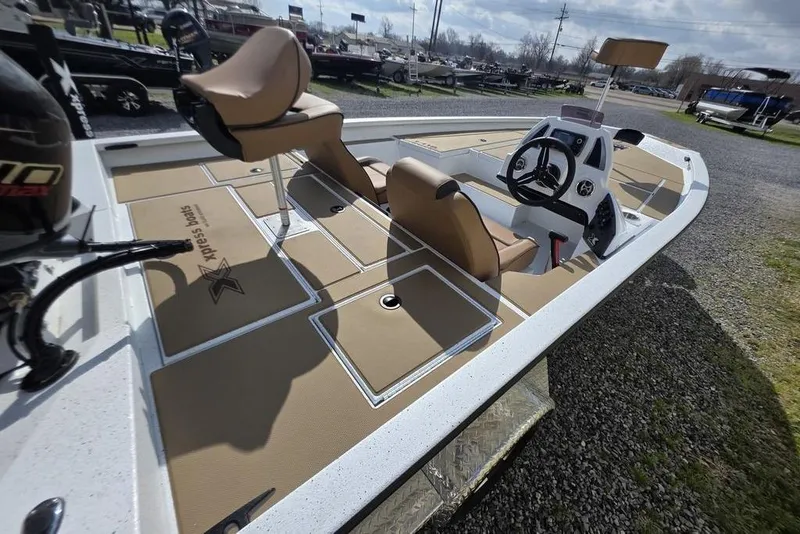 Slide: The Image of 2026 Xpress H18 boat interior with tan seating and steering console on display. - 9
