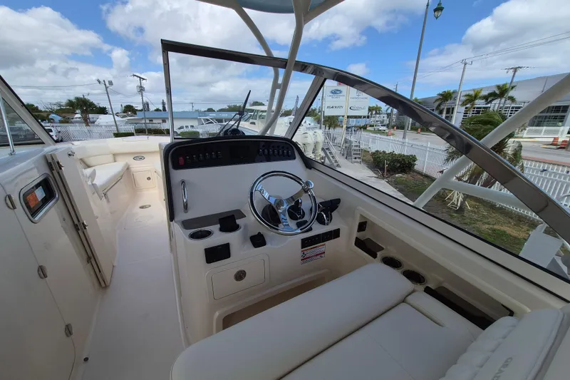 Slide: The Image of 2026 Grady-White Freedom 307 boat interior with steering wheel and seating area. - 12