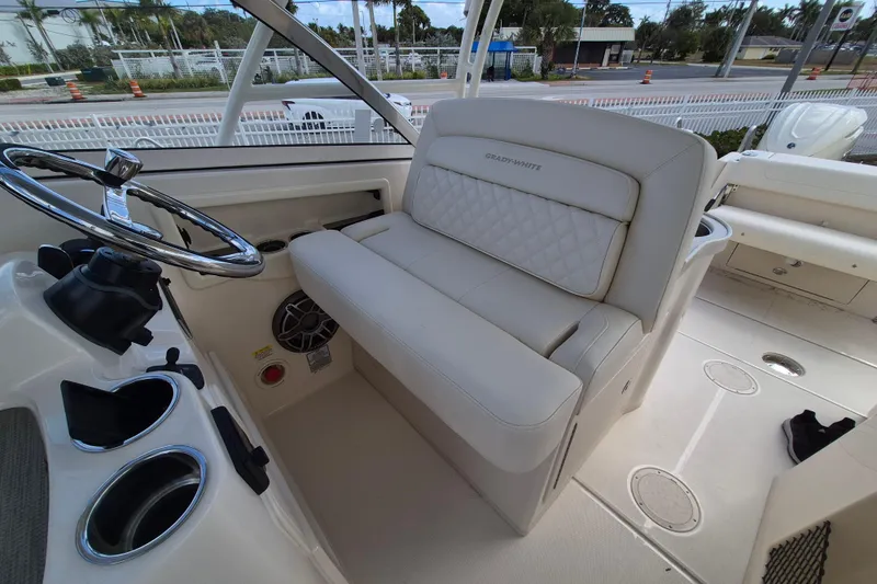 Slide: The Image of 2026 Grady-White Freedom 307 boat interior with steering wheel and cushioned seating. - 13