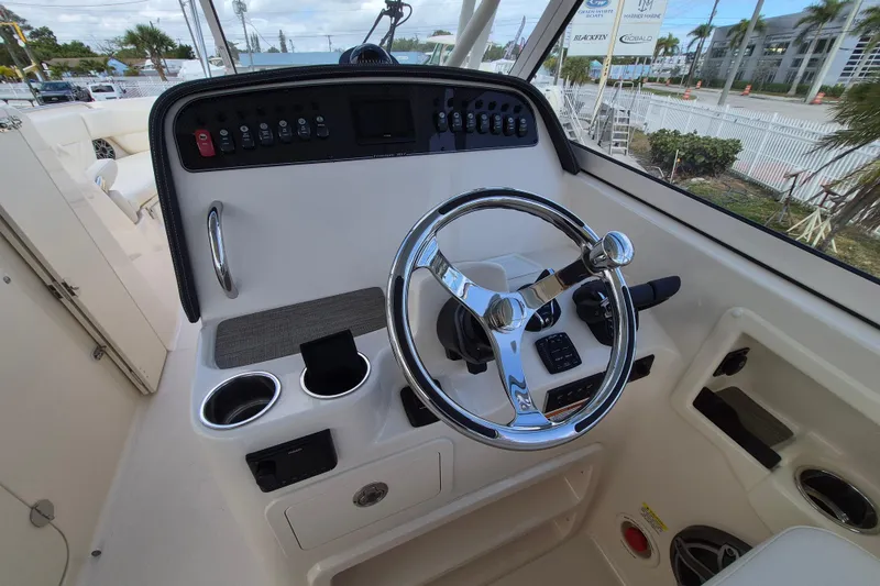 Slide: The Image of 2026 Grady-White Freedom 307 boat helm with chrome steering wheel and control panel. - 14