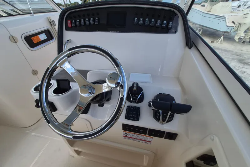 Slide: The Image of 2026 Grady-White Freedom 307 boat helm with steering wheel and controls. - 15