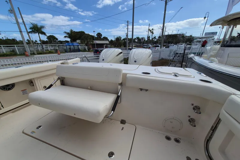 Slide: The Image of 2026 Grady-White Freedom 307 boat interior with seating and controls, under a clear sky. - 21