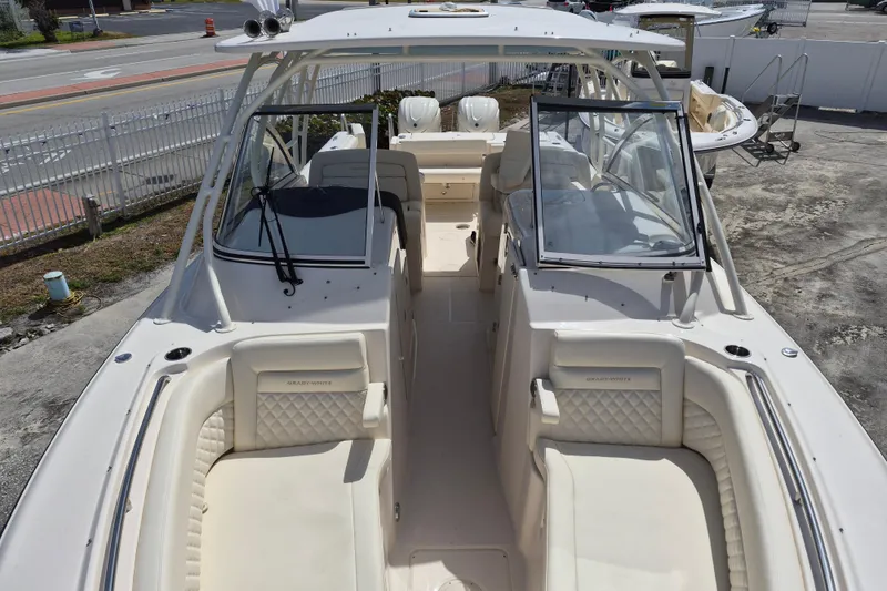 Slide: The Image of 2026 Grady-White Freedom 307 boat interior with seating and windshield, docked outdoors. - 5