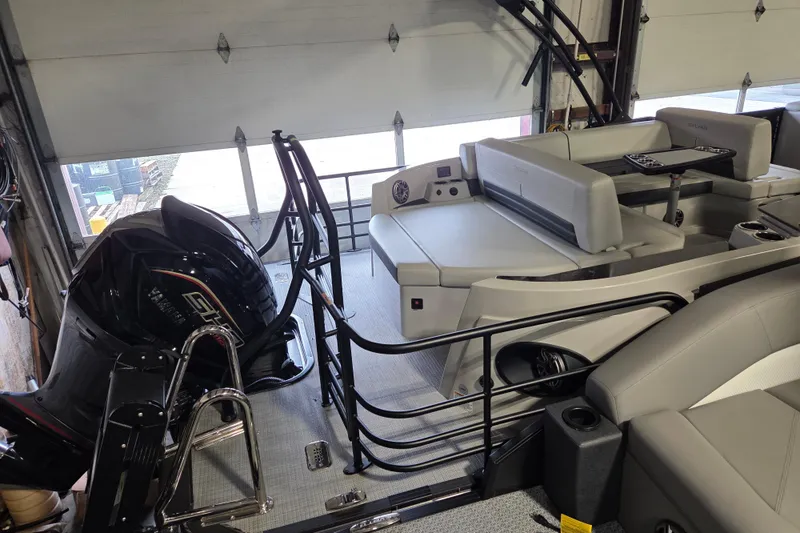 Slide: The Image of 2025 Sylvan G3 CLZ boat interior with seating and motor in a garage setting. - 2