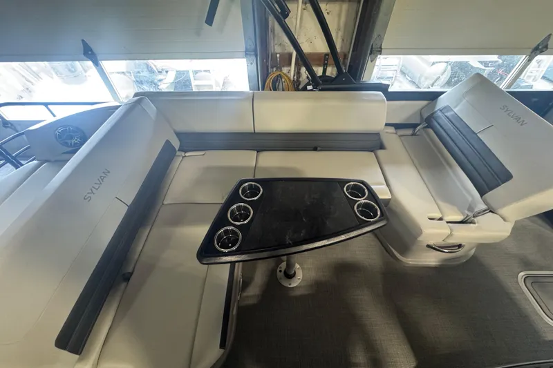 Slide: The Image of 2025 Sylvan G3 CLZ boat interior with cushioned seating and a central table. - 22