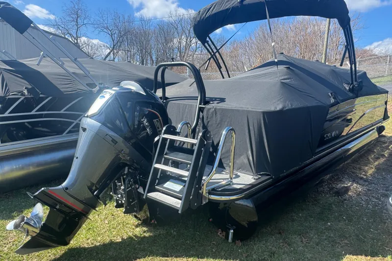Slide: The Image of 2025 Sylvan G3 CLZ pontoon boat with cover and outboard motor, parked outdoors. - 37