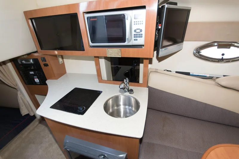Slide: The Image of Interior of 2006 Maxum 2600 SE with kitchenette and seating area. - 17