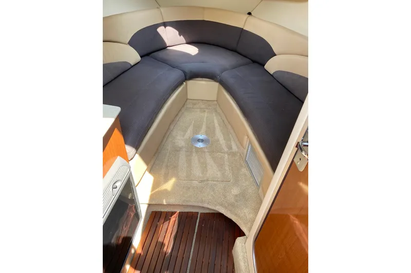 Slide: The Image of 2006 Maxum 2600 SE cabin interior with plush seating and carpeted flooring. - 20