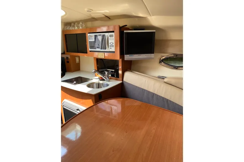 Slide: The Image of 2006 Maxum 2600 SE boat interior with kitchenette, sink, microwave, and TV. - 21