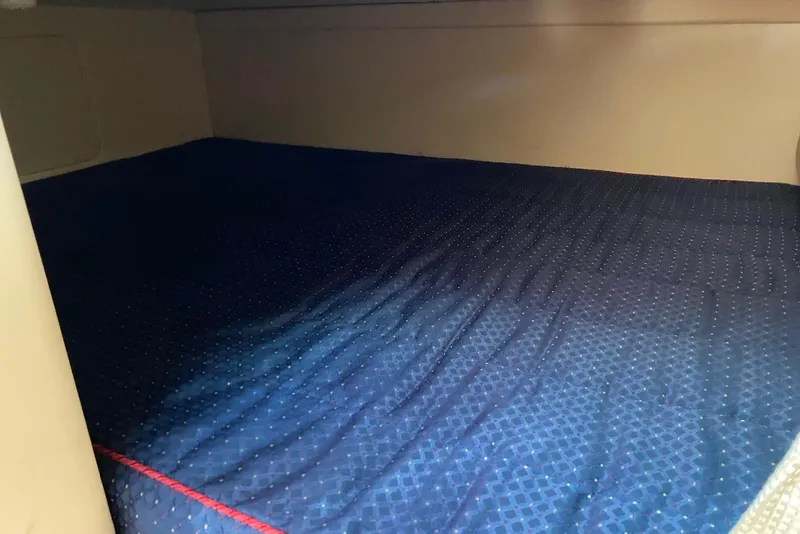 Slide: The Image of Interior cabin bed of 2006 Maxum 2600 SE boat with blue bedding. - 24